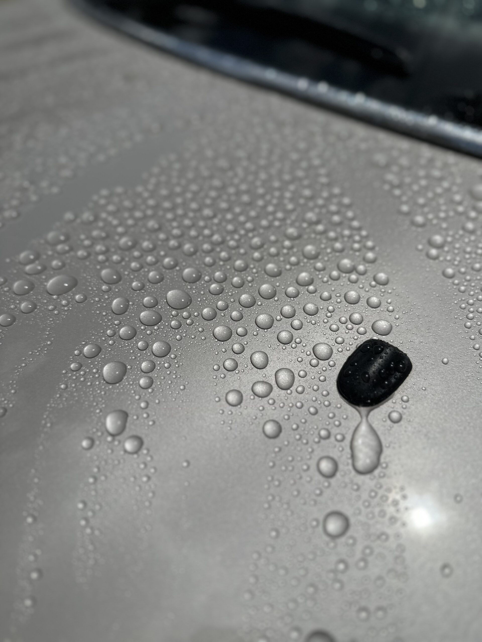 撥水したシルバーのボディに残る大小の水滴