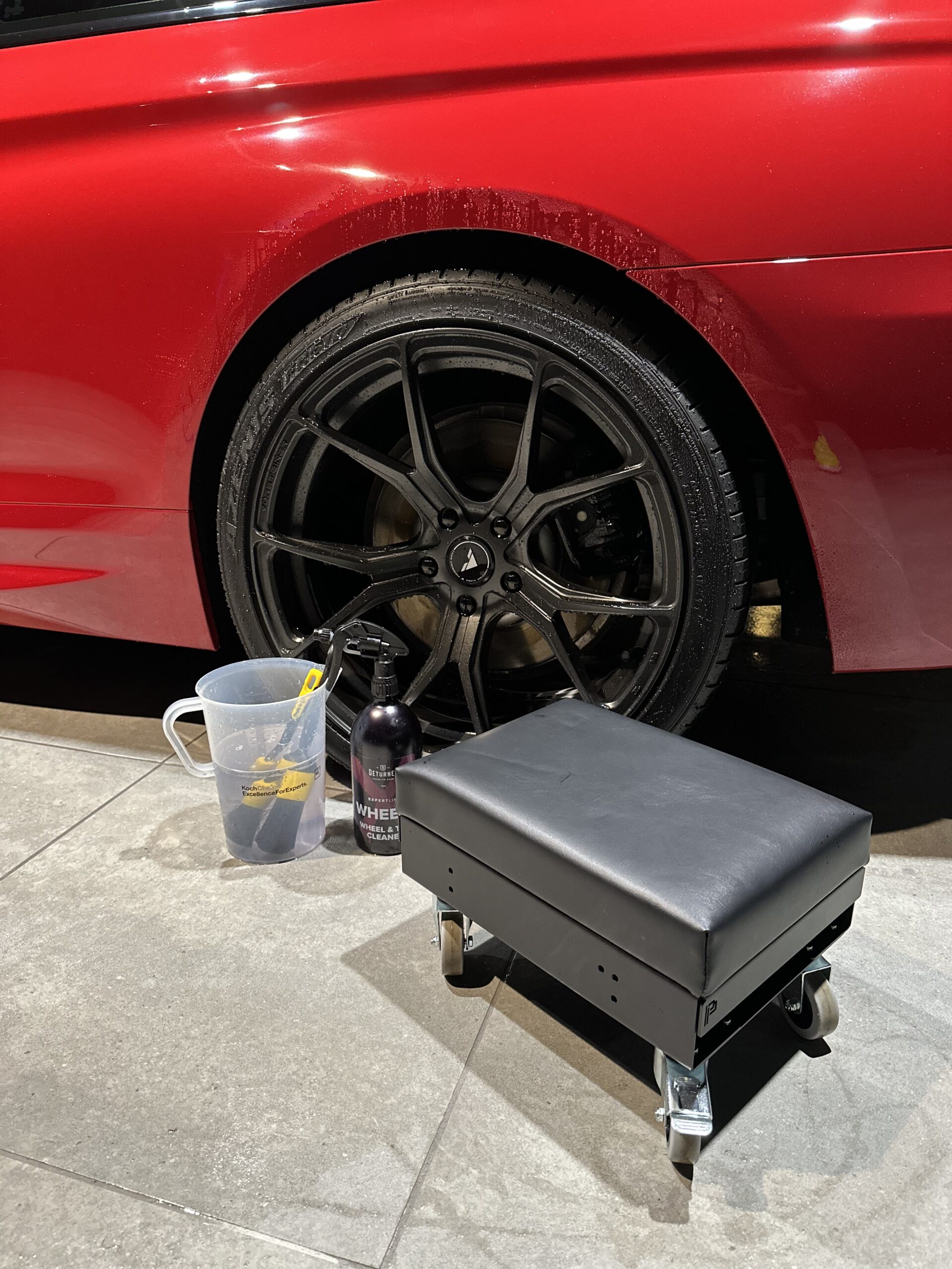 POKA PREMIUM Detailing seat/hassockに座ってホイールを洗う様子