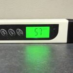 純水器の水質測定に使うTDS&ECメーターの導電率モードで水道水を測定し57µS/cmと表示された画面